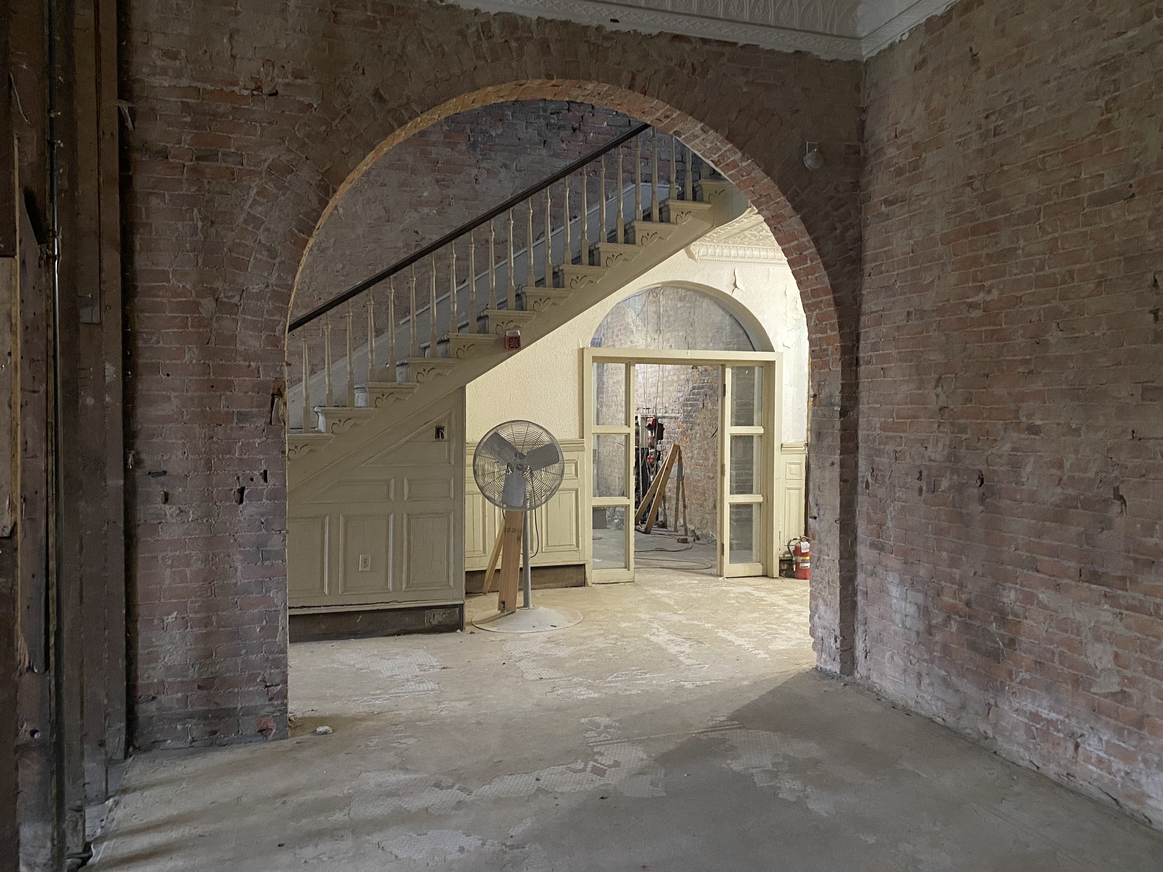 Archway showing flight of stairs in background.